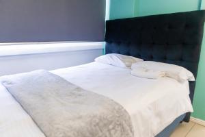 una camera da letto con un letto con lenzuola e cuscini bianchi di Modern apartments at CZ KUBS a East London