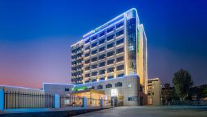 a large building is lit up at night at Holiday Inn Express Longyan Liancheng by IHG in Lien-ch'eng-hsien