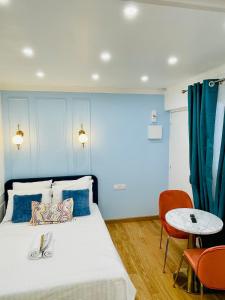 a blue room with a bed and a table at Chic Apartment Arc de Triomphe-Champs Élysées in Paris