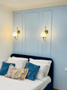 a bed with two lights and two pillows on it at Chic Apartment Arc de Triomphe-Champs Élysées in Paris