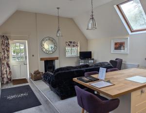 a living room with a couch and a table at The Coach House Apartment at Cefn Tilla Court, Usk in Usk