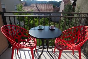 two red chairs and a table on a balcony at Montenegrina apartment in Cetinje