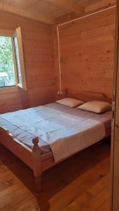una camera con un letto in una baita di tronchi di comjun a Ada