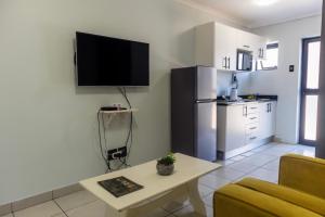a living room with a couch and a tv on the wall at Grace Villas 8 in East London