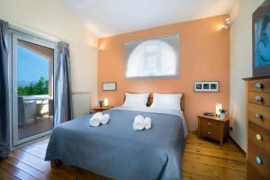 a bedroom with a bed with two towels on it at Villa Olivo Kampani in CHQ +66 photos