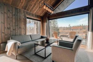 a living room with a couch and a table at Modern Mountain Cabin - Outdoor Hot Tub - 8 Beds in Torpo