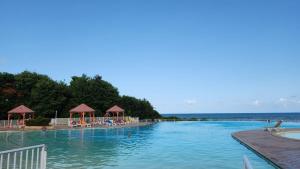 a large swimming pool with the ocean in the background at Anse des Rochers Paradise in Saint-François