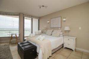 a bedroom with a bed with a view of the ocean at Hibernian Towers 402 Self Catering Accommodation Strand Western Cape South Africa in Cape Town +9 photos