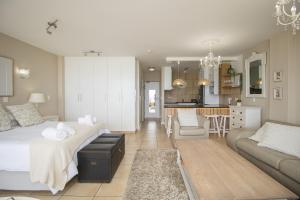 a bedroom with a bed and a living room at Hibernian Towers 402 Self Catering Accommodation Strand Western Cape South Africa in Cape Town