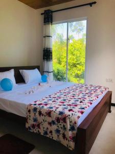 a bedroom with a large bed with a window at Cinnamon garden villa in Weligama