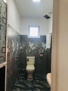 a bathroom with a toilet and a window at Cinnamon garden villa in Weligama