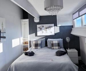 a bedroom with a bed with blue walls and a chandelier at St Andrews house Hotel in Preston