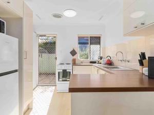 une cuisine avec des appareils blancs et une grande fenêtre dans l'établissement Beach Getaway Villa 2br Fun!, à Bicton 7 autres photos