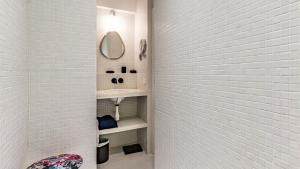 une salle de bain blanche avec un lavabo et un miroir dans l'établissement APPARTEMENT avec vue sur la Seine 10' en voiture de Paris et de la Tour Eiffel, à Boulogne-Billancourt