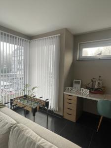 ein Schlafzimmer mit Bett, Schreibtisch und Fenster in der Unterkunft Zeegidss in Ostende