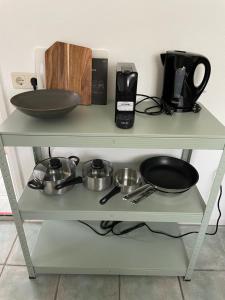 a shelf with pots and pans on it at Beachhouse De Dahlia in Noordwijk aan Zee +6 photos