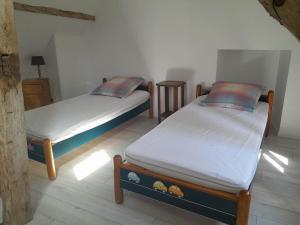 2 łóżka pojedyncze w pokoju z: w obiekcie Agréable et jolie maison avec grand jardin w mieście Pellevoisin