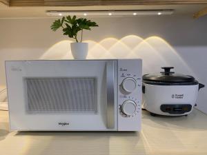 a microwave and a toaster oven on a counter at Modern Condo, Sea View, Fast Wifi, Cafe, Panglao in Dauis