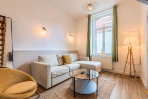 a living room with a couch and a table at Maison 3 chambres avec jardin, proche tram in Mouvaux