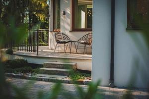two chairs sitting on the porch of a house at Pomiedzy debami - domki in Emilia