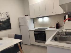 Una cocina con un refrigerador blanco y un fregadero. en Stylish Downtown Apartment - Tsimiski - Ladadika - Walk Everywhere, en Tesalónica