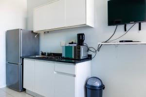 una cucina con mobili bianchi e un frigorifero di CZ Kubs 43 a East London