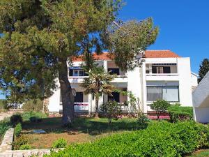a white house with a tree in front of it at Apartment Doris in Šibenik