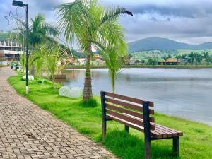 a park bench sitting next to a body of water at Flat com Jacuzzi em Capitólio - Cantinho do Lago 1 in Capitólio