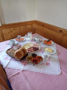 a table with plates of food on a pink table cloth at Ausserstauderhof in San Leonardo in Passiria +20 photos