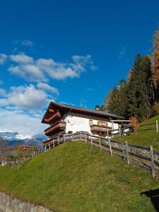 a barn on a hill with a fence at Ausserstauderhof in San Leonardo in Passiria