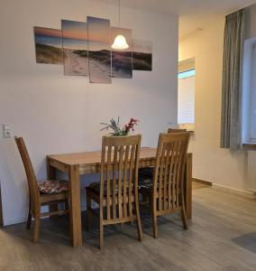 ビューズムにあるIdeal für den Familienurlaubの木製のテーブルと椅子のあるダイニングルーム