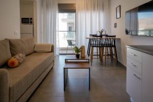 una sala de estar con un sofá y una mesa en Red Sea Icon - by G&P Suites, en Eilat
