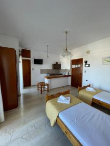 a living room with two beds and a kitchen at Aeolos Apartments Kolymbari in Kolymvari +51 photos
