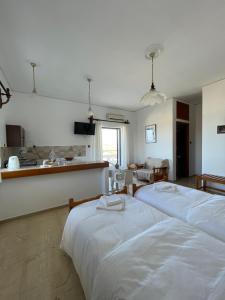 two beds in a room with a kitchen and a kitchen at Aeolos Apartments Kolymbari in Kolymvari