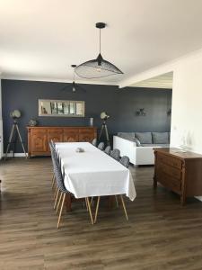 a living room with a white table and a bed at Maison de famille de 150 m2 à 15 minutes de la mer in Coëx