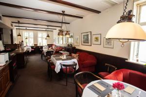 a dining room with tables and red chairs and a restaurant at Hotel Zur Linde in Meldorf