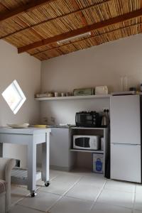 a kitchen with a white table and a microwave at Skrywerskop in Prince Albert