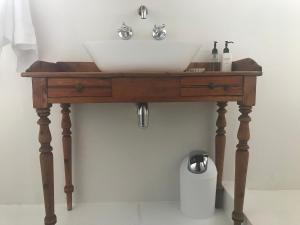 a wooden bathroom vanity with a sink on it at Skrywerskop in Prince Albert +9 photos