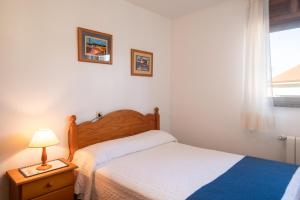 ein Schlafzimmer mit einem Bett und einer Lampe und einem Fenster in der Unterkunft Casa vacacional El Angel in La Pesa