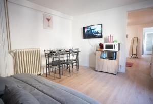 a living room with a table and a microwave at L' escale SAINT ANNE in Reims