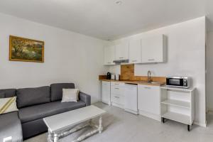 a living room with a couch and a kitchen at Le Bambou Wifi Proche des pontons et du Doul in Peyriac-de-Mer