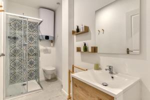 a bathroom with a sink and a shower and a toilet at Le Bambou Wifi Proche des pontons et du Doul in Peyriac-de-Mer