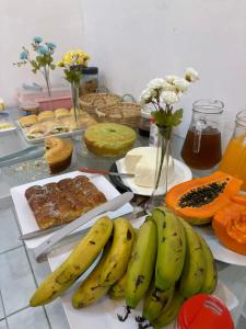 a bunch of bananas on a table with other foods at Hotel Perola Ltda in Cuiabá