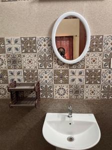a bathroom with a sink and a mirror at Grandir Inn Villa in Mahabalipuram