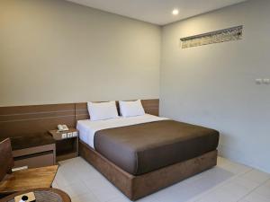 a small bedroom with a bed and a telephone at Amerta Giri Hotel Dieng Wonosobo in Kejajar +15 photos