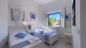 a bedroom with two beds and a window at Villa la Bonaccia in La Maddalena +41 photos