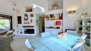 a dining room with a glass table and chairs at Villa la Bonaccia in La Maddalena