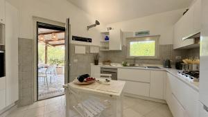 a kitchen with white cabinets and a table in it at Villa la Bonaccia in La Maddalena