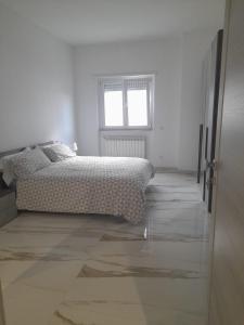 Un dormitorio blanco con una cama y una ventana. en Casa Vacanze Marco e Cinzia, en Roma