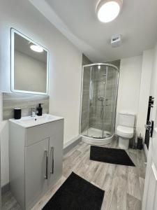a bathroom with a shower and a sink and a toilet at Two Bedroom Flat by Brookland Stays Serviced Accommodation Short Lets Leeds with Free WiFi in Yeadon